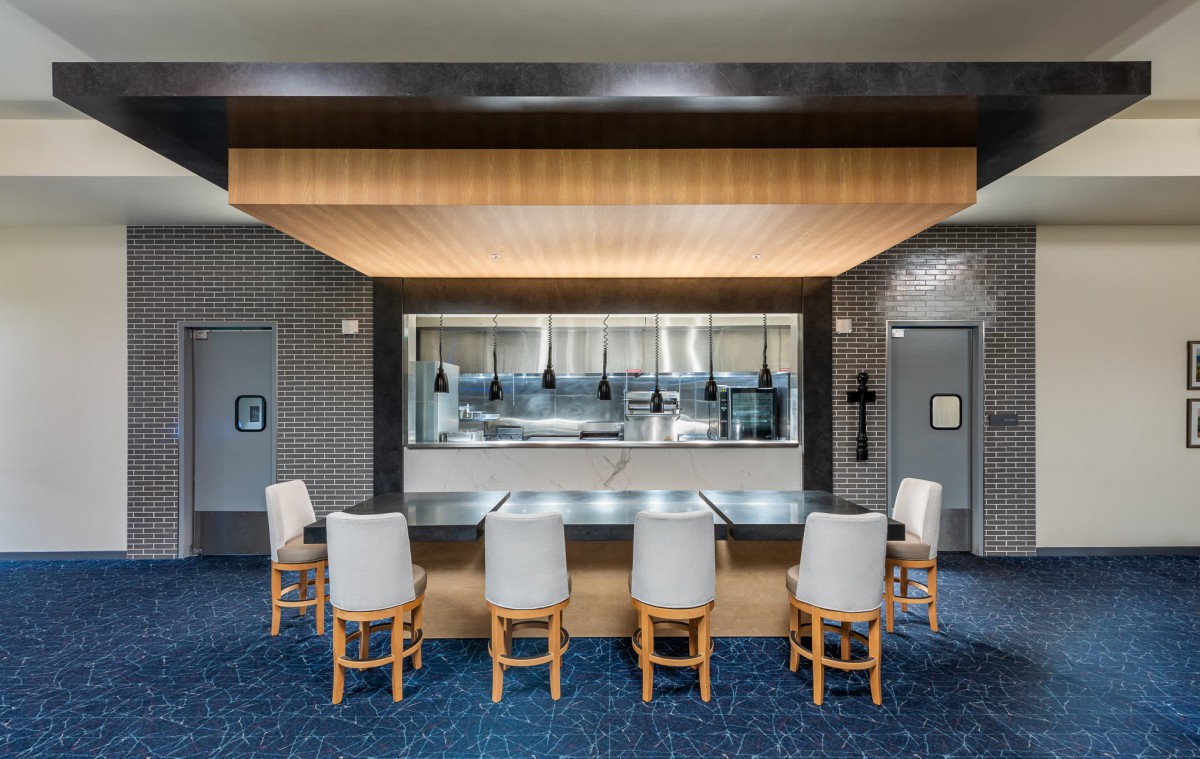 A modern restaurant interior with bar seating and ambient lighting.