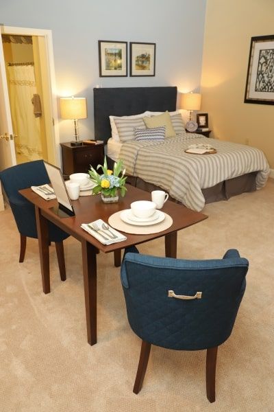 A cozy bedroom with a small dining table setup, featuring modern and minimalist decor.