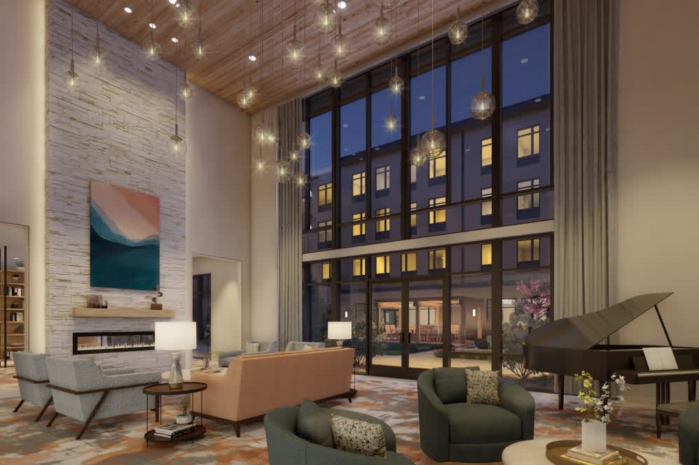 A modern lobby with comfortable seating, large windows, and ambient lighting.