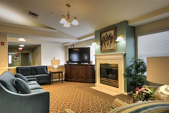 A cozy living room featuring a fireplace, large TV, and comfortable seating area.