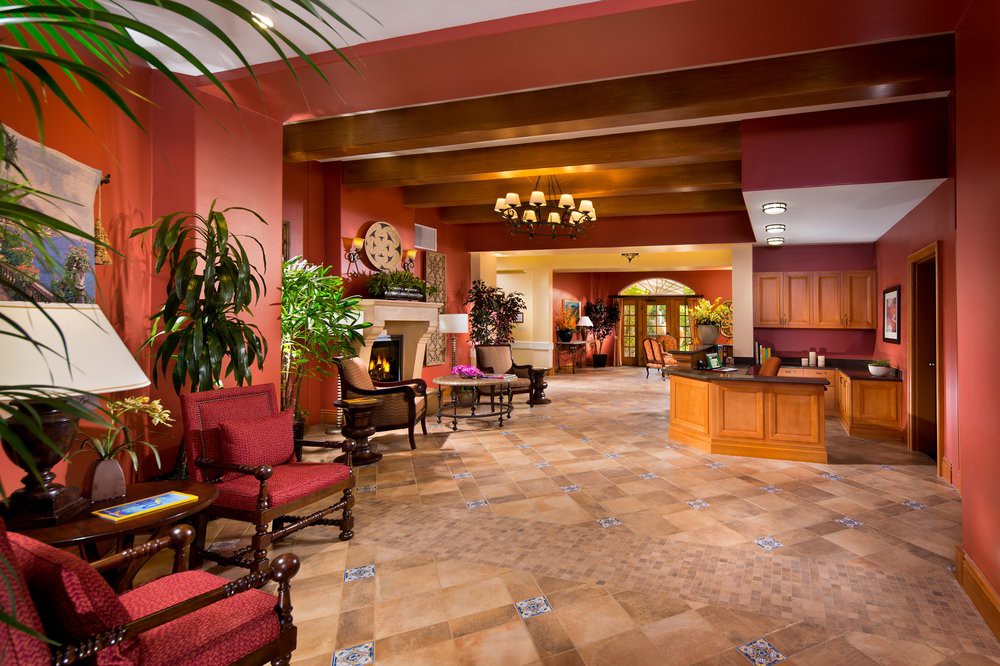 A warmly decorated hotel lobby with comfortable seating and greenery.