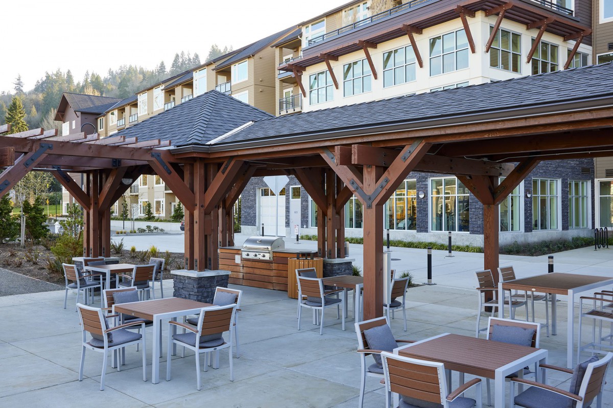 An outdoor dining area with wooden pergolas and modern seating arrangements.