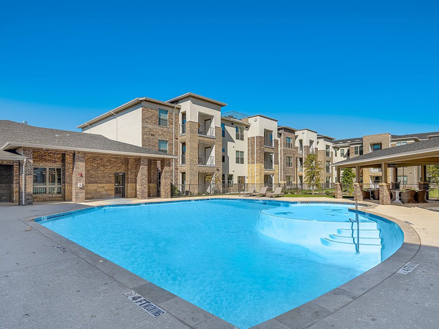 Modern apartment complex with a large outdoor swimming pool.