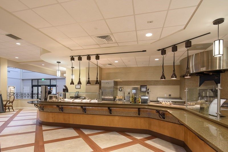 A modern cafeteria interior with an empty food service counter and stylish lighting.
