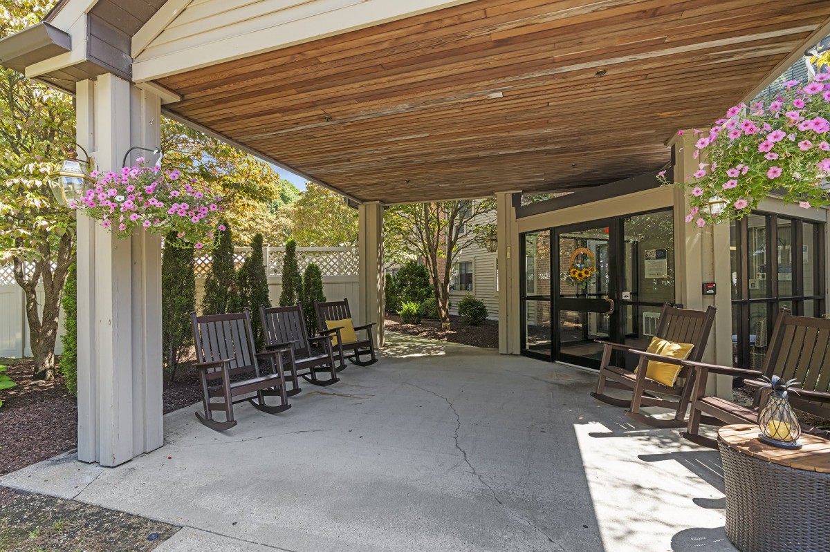 A cozy outdoor porch with rocking chairs and a covered patio area.