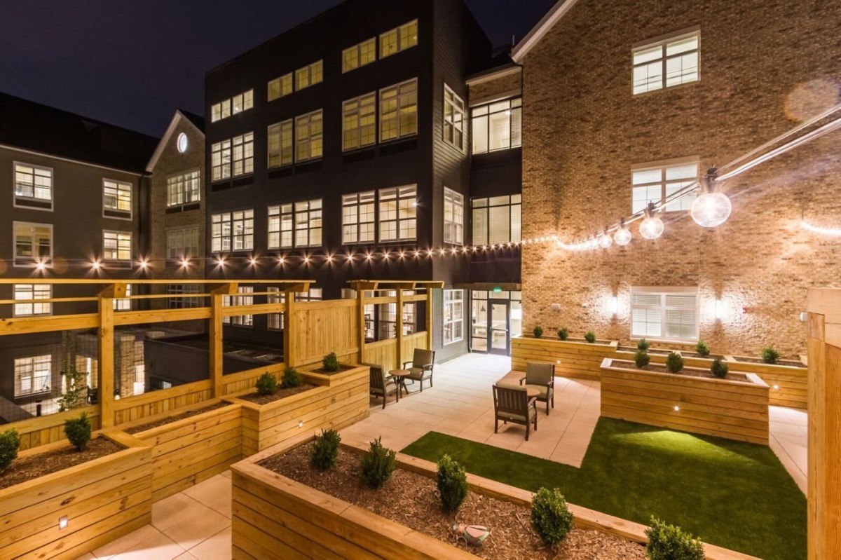 An inviting outdoor patio area with modern lighting and architecture at night.