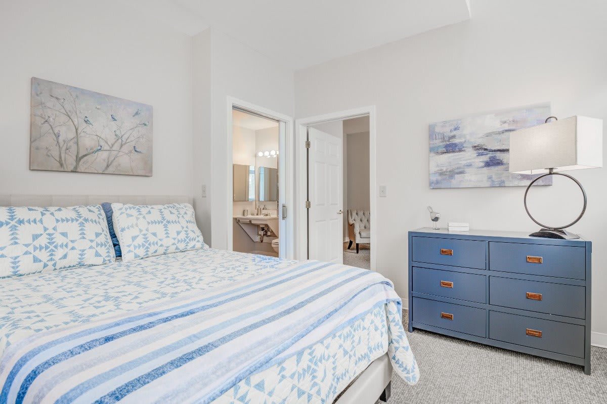 A cozy bedroom with a neatly made bed and soothing decor.