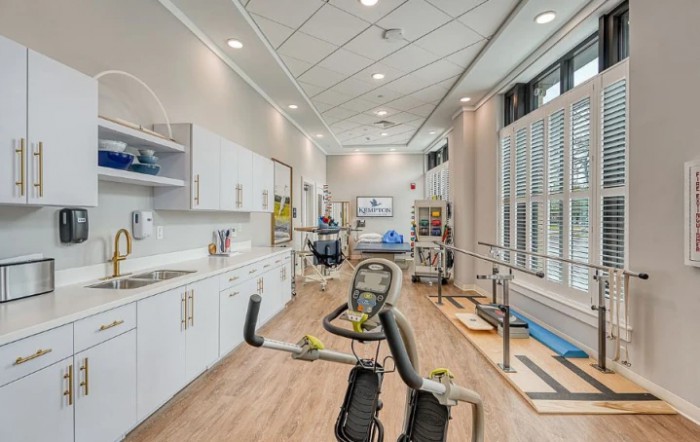 A modern rehabilitation room equipped with exercise machines and therapy tools.