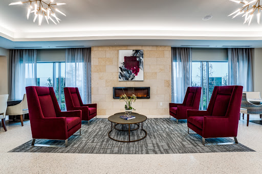 A stylish modern lounge area with red chairs and contemporary artwork.
