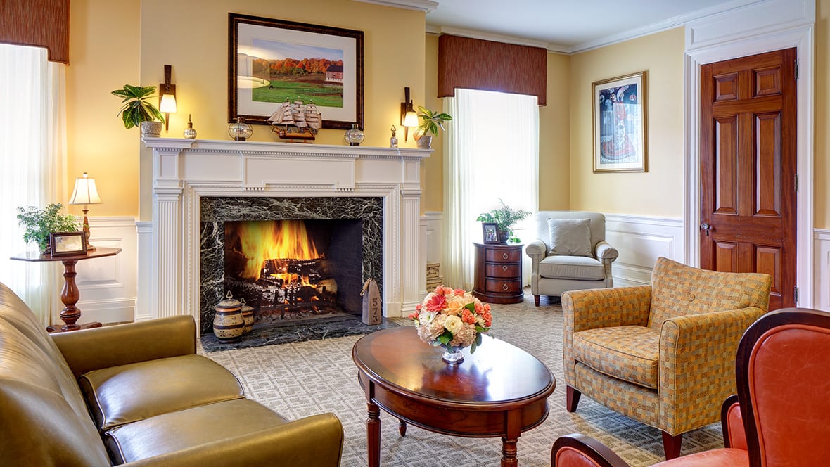 A cozy living room with a warm fireplace, elegant furniture, and traditional decor.