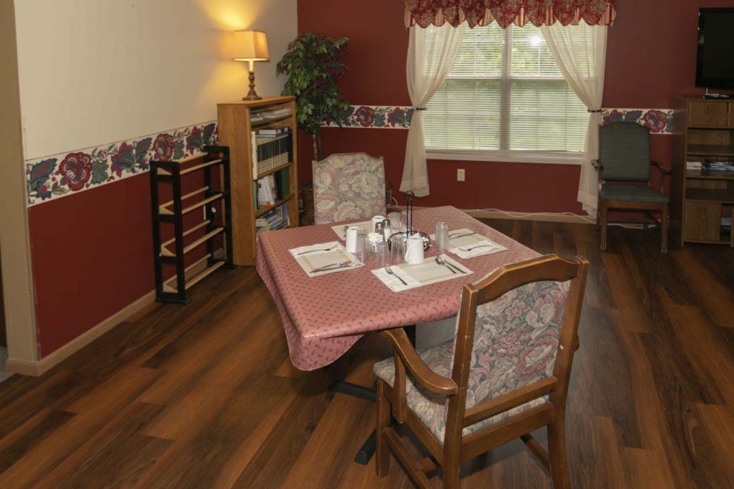 A cozy dining room setup with a table and chairs, complemented by warm lighting and elegant decor.