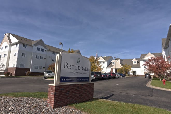 A view of the Brookdale retirement home with its sign and parking lot.