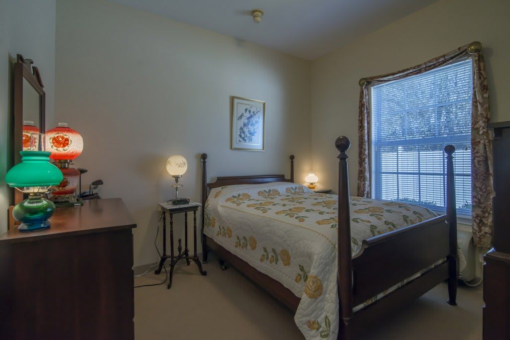 A cozy bedroom with a large wooden bed and soft lighting from bedside lamps.