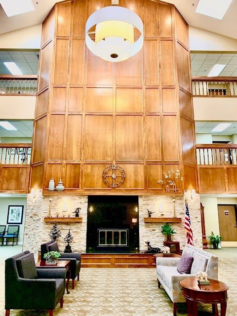A spacious lobby with wood paneling and elegant furnishings.
