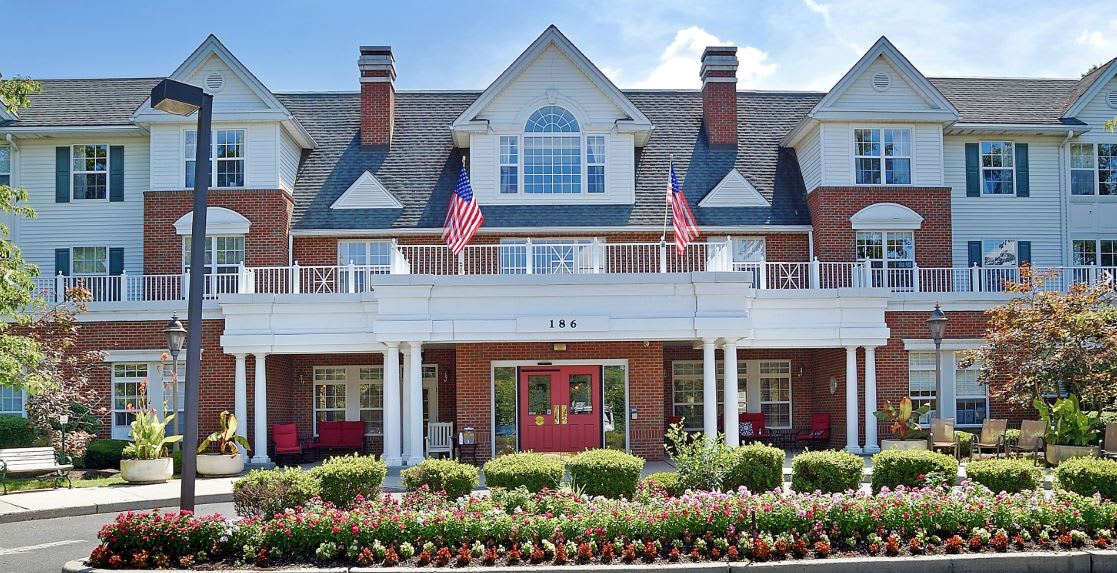 A traditional residential building with American flags and well-maintained landscaping.