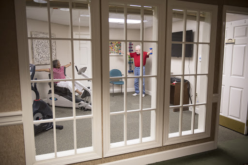 Participants engaged in a physical therapy session in a rehabilitation room, focusing on fitness and recovery.
