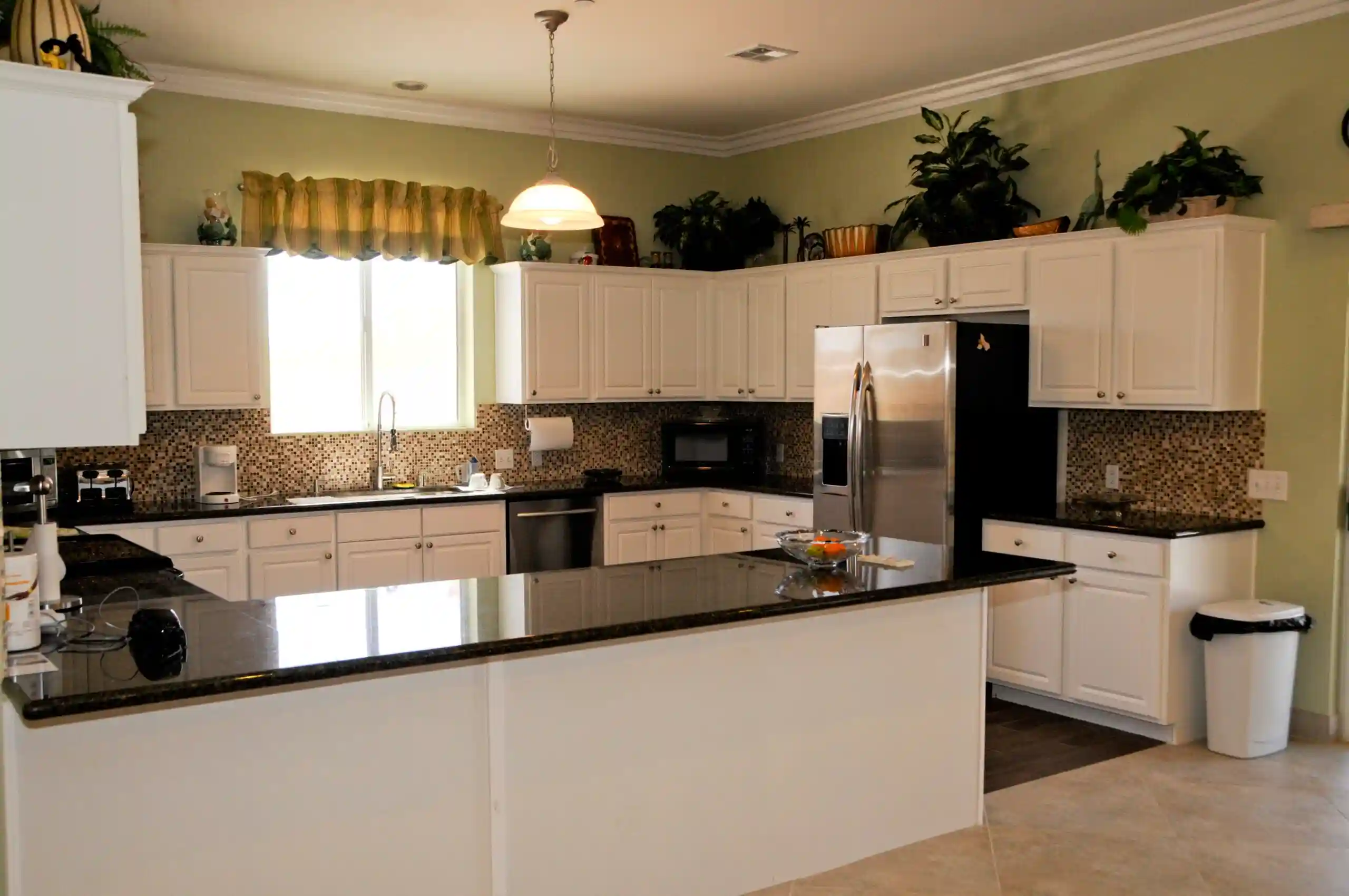 A modern kitchen featuring white cabinets and stainless steel appliances.