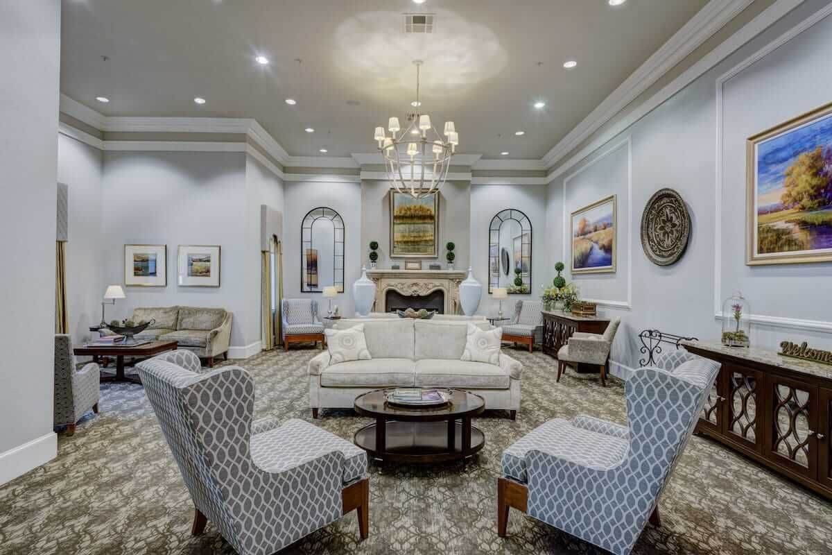 A beautifully designed living room with classic furnishings and a central chandelier.