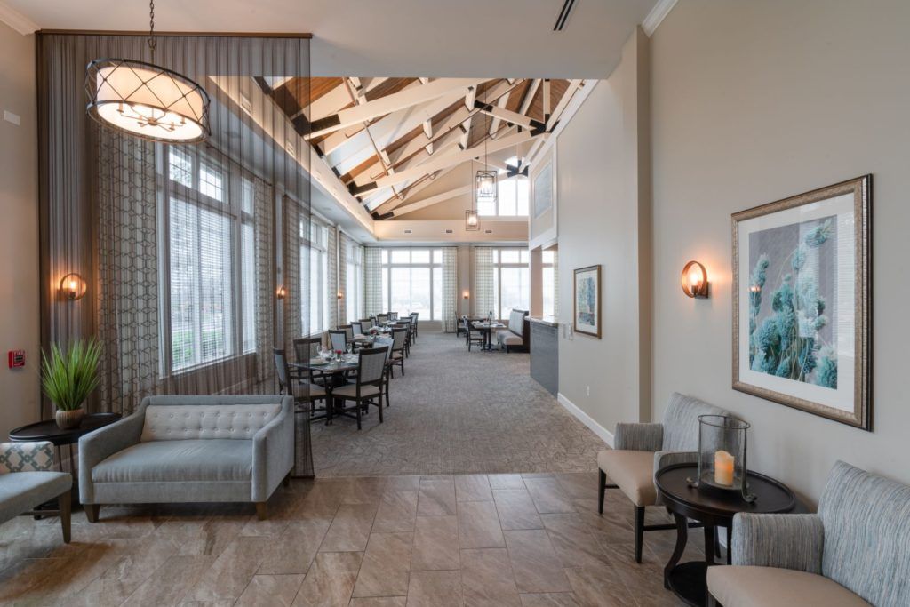 A spacious lounge area with ample seating and large windows allowing natural light to flood the room.