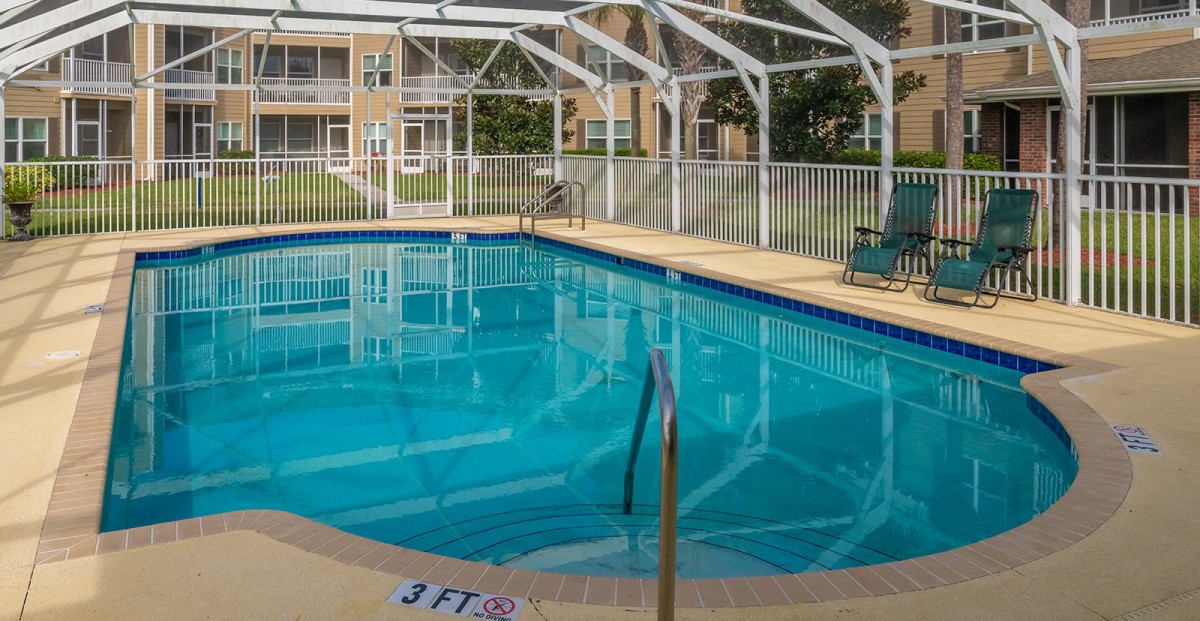 An indoor swimming pool enclosed by a transparent structure, ideal for leisure and relaxation.