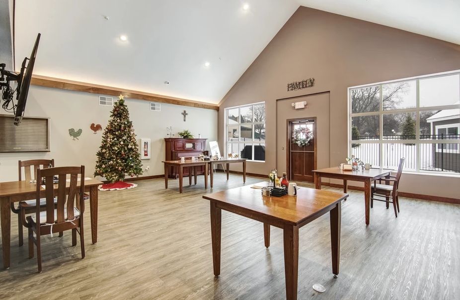 A warmly decorated room with wooden tables and a Christmas tree.