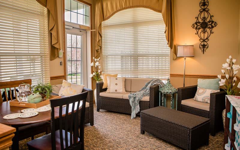 A cozy living room with stylish furniture and soft lighting, featuring large windows and elegant decor.