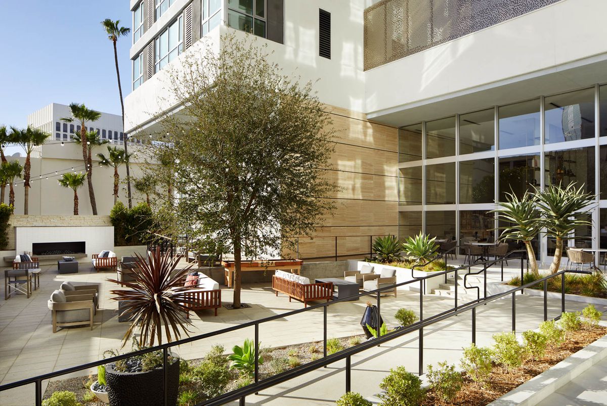 A modern outdoor patio area with seating and plants in an urban setting.
