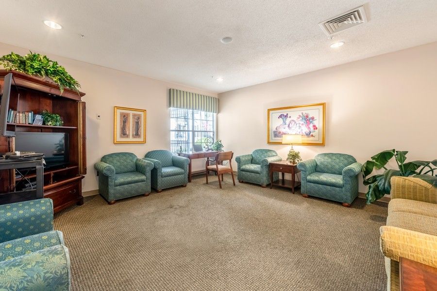 A cozy living room with teal chairs, a small table, and wall art.