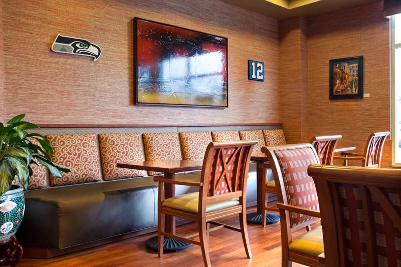 A cozy restaurant interior featuring comfortable seating with tables and decorative wall art.