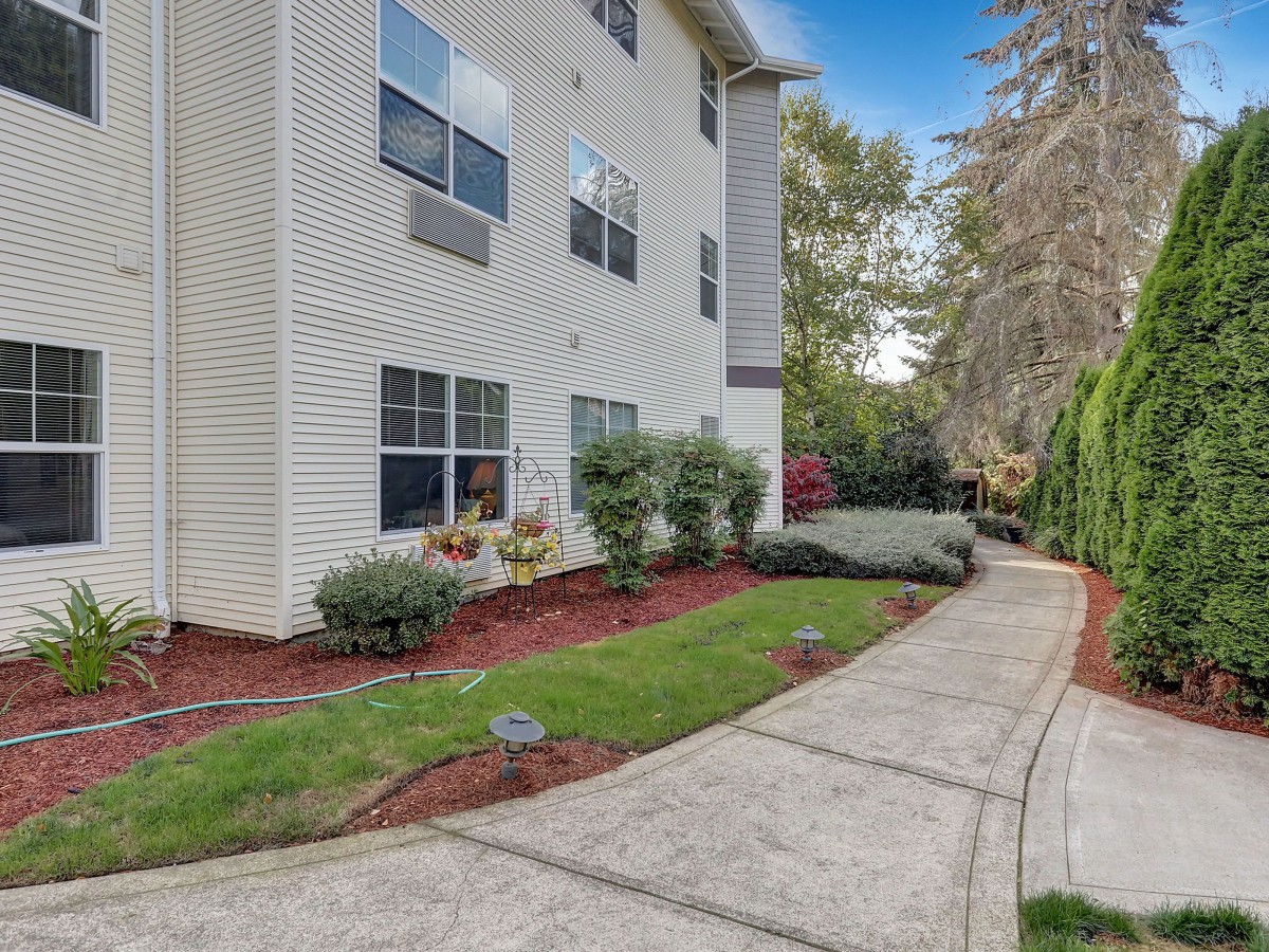 A well-maintained apartment building with a landscaped path and greenery.