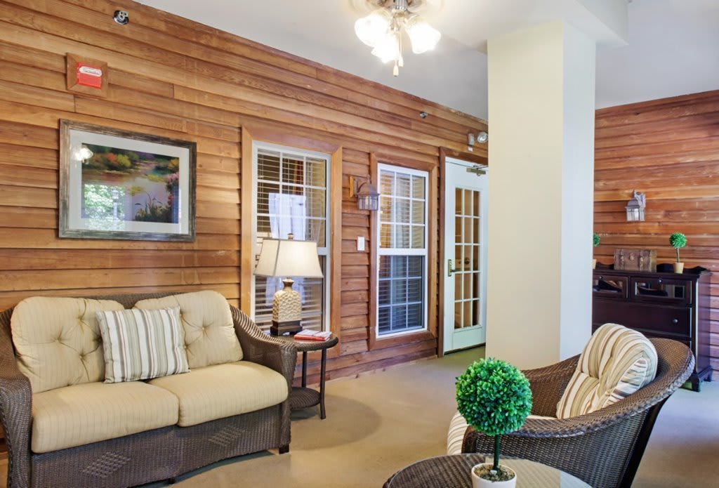 Cozy living room with wooden walls and comfortable seating.