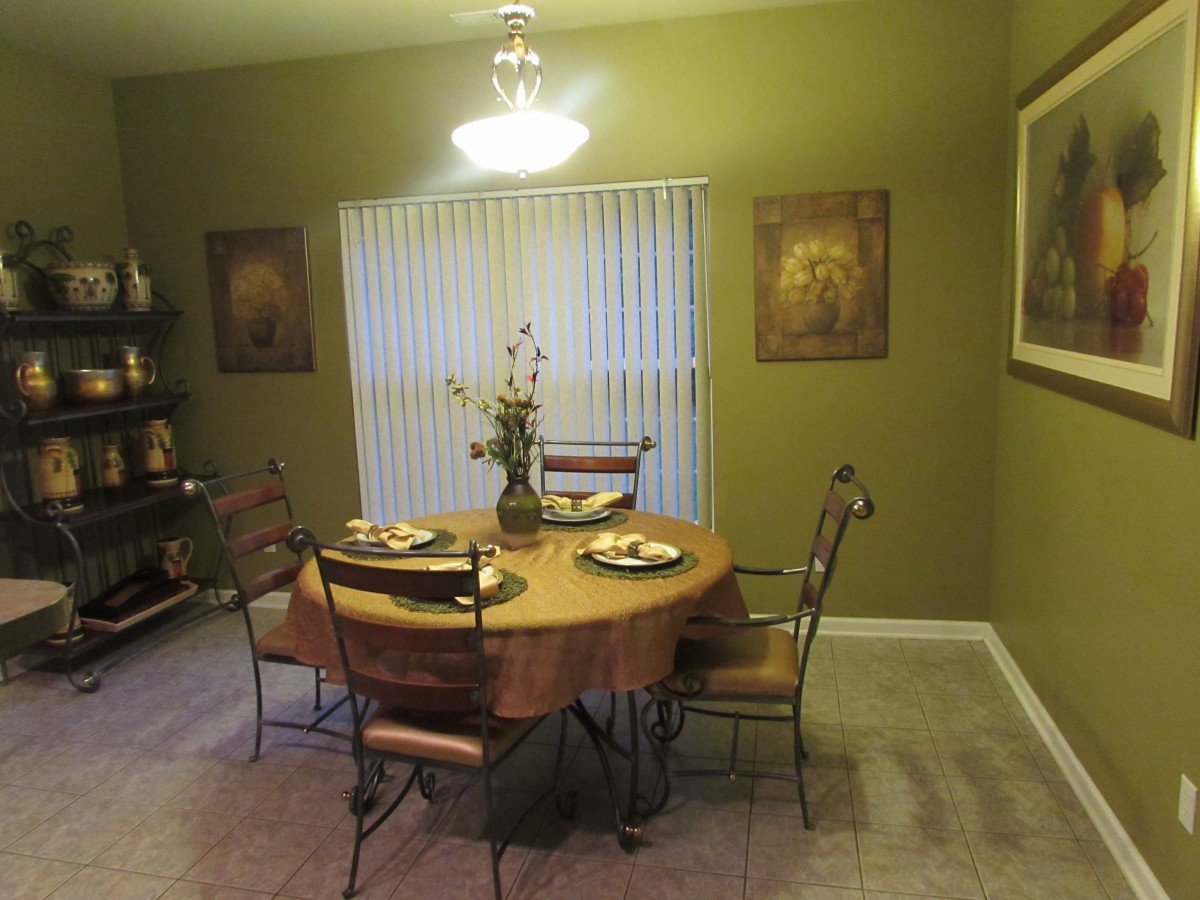 A cozy dining room with a round table set for four, surrounded by elegant decor and warm lighting.
