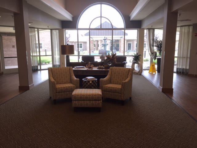 A cozy lobby area with seating and large windows providing natural light.