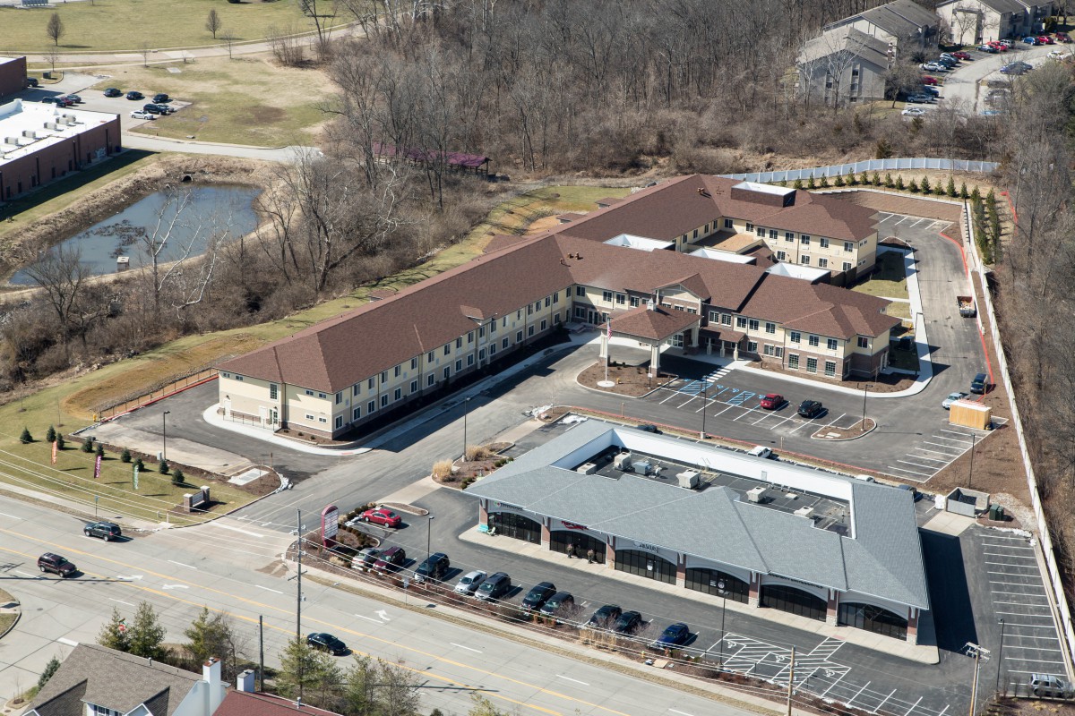Aerial view of a complex with multiple buildings and a parking lot.