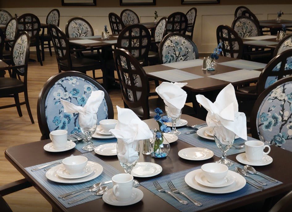 An elegant restaurant dining setup with neatly arranged place settings and folded napkins.