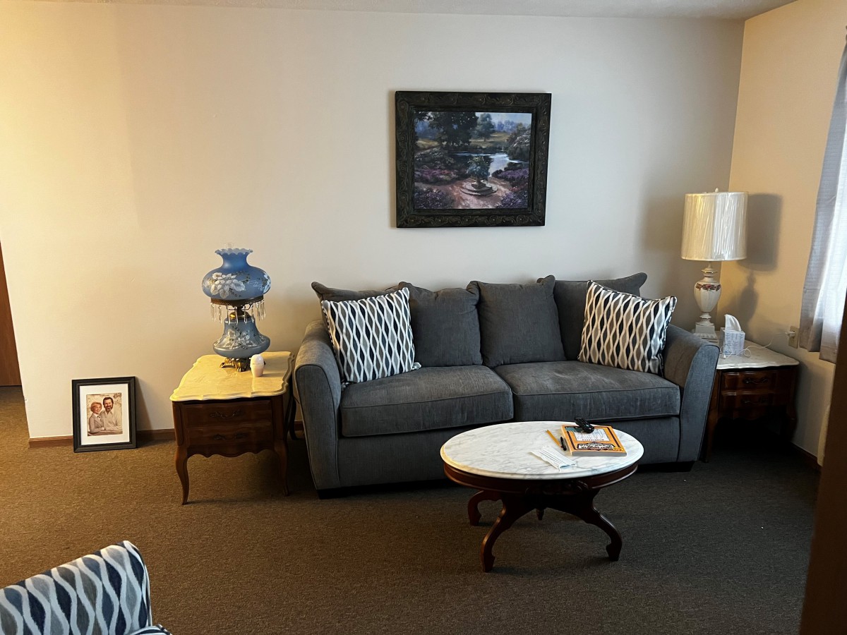 A cozy living room with a gray sofa, patterned cushions, and a coffee table.