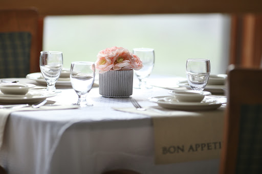 An elegantly set dining table adorned with flowers, perfect for a special occasion.