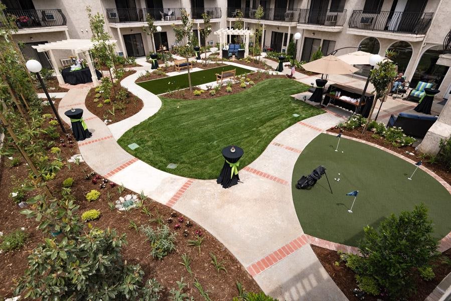 A well-maintained courtyard featuring a lush green lawn and winding pathways.