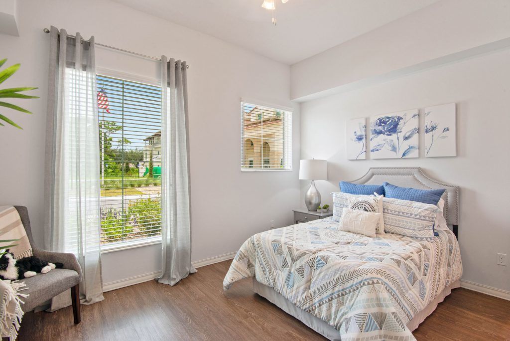 A modern, bright bedroom with large windows allowing natural light to fill the space.
