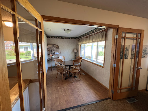 A cozy dining space featuring wooden furniture and ample natural light.