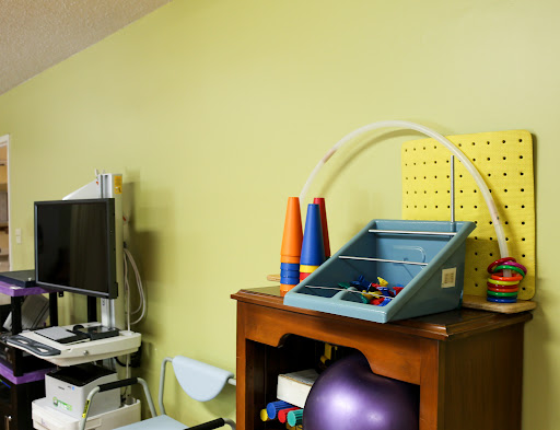 A therapy room showcasing various equipment and colorful toys.