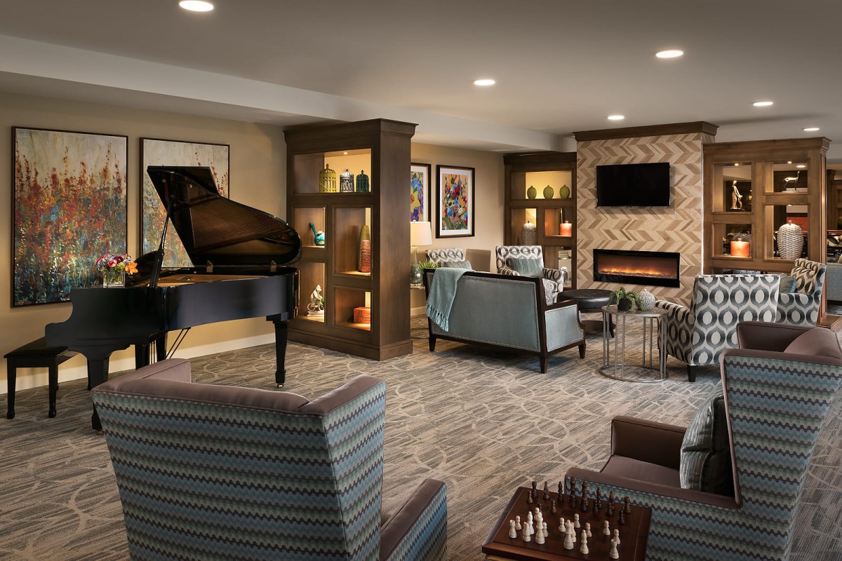 A modern living room with a piano, fireplace, and cozy seating area.