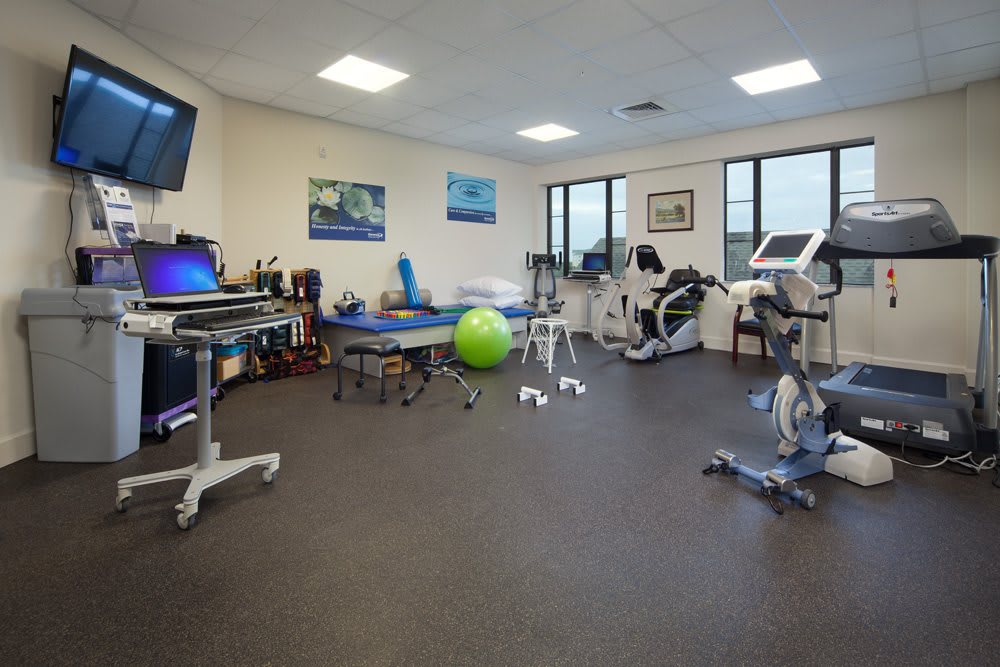A well-equipped physical therapy room featuring various exercise machines and rehabilitation tools.
