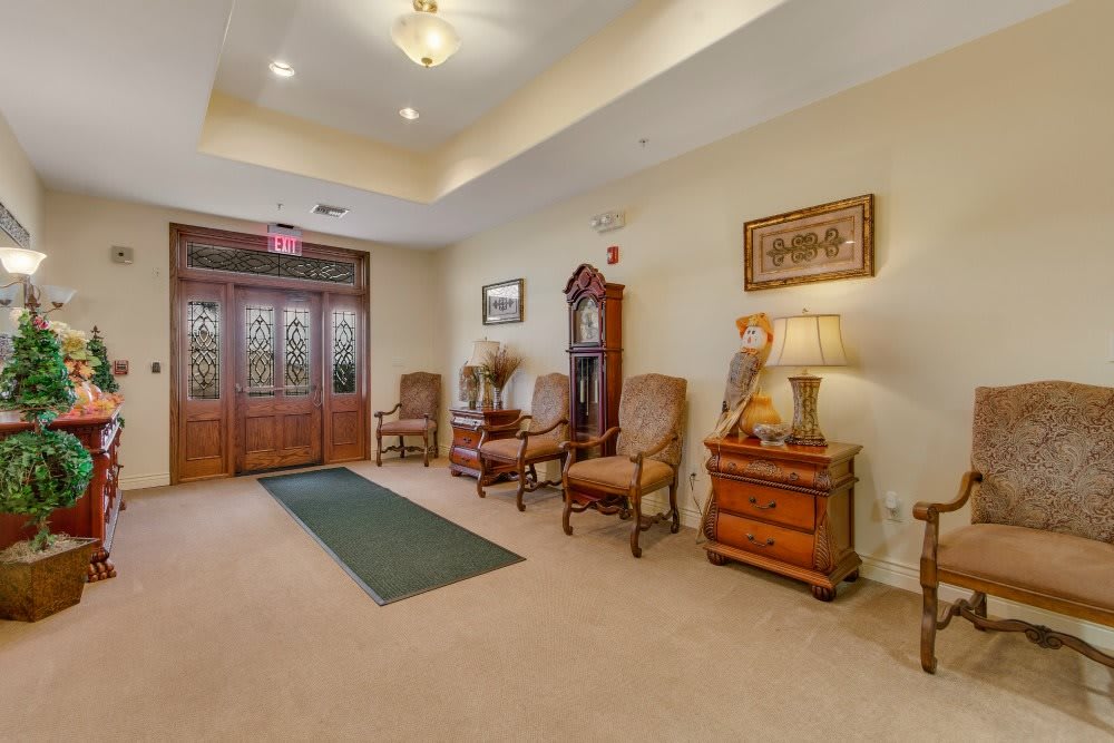 A cozy lobby area with wooden doors, elegant furniture, and warm lighting.