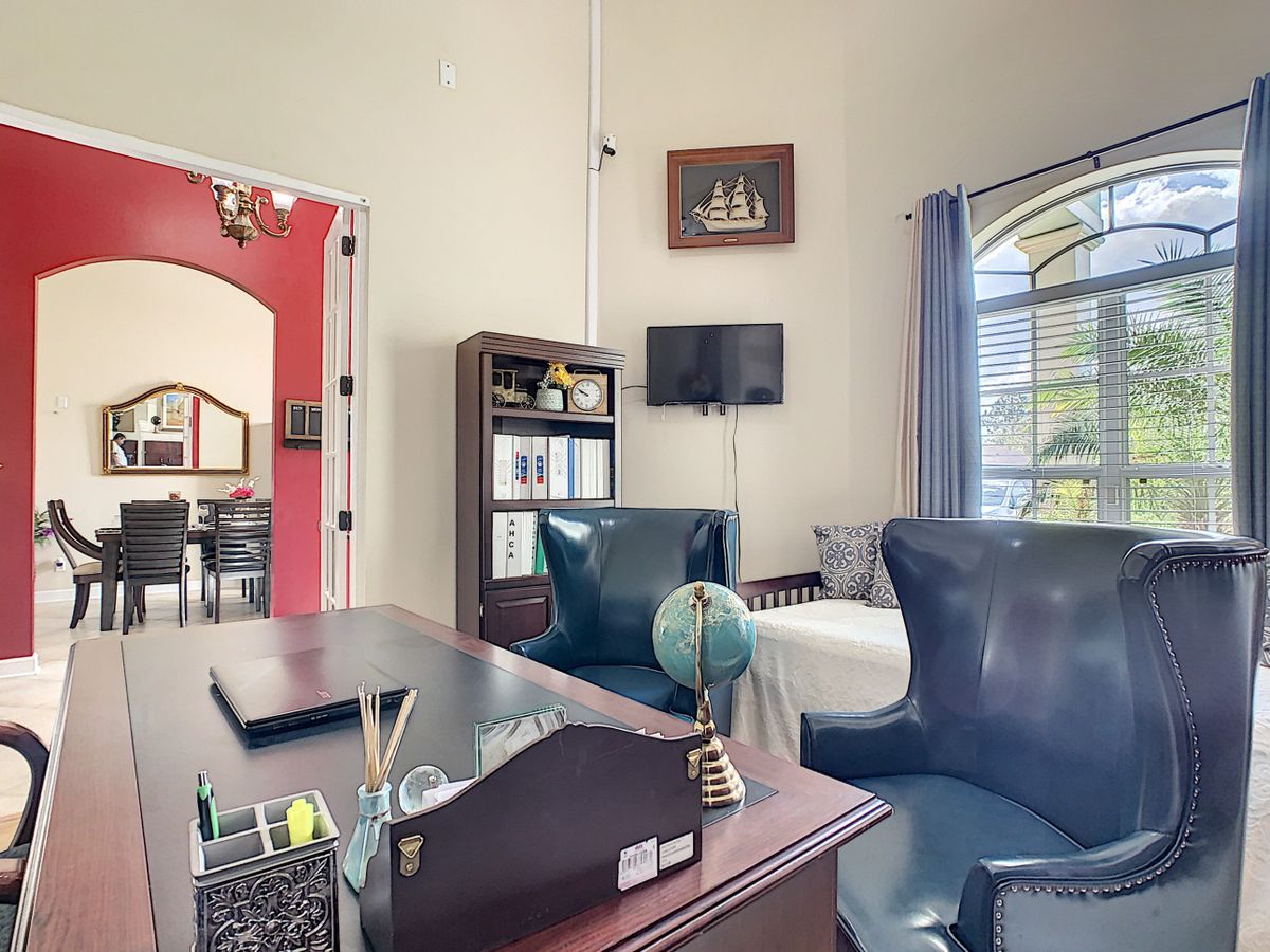 A well-organized home office with a desk, chairs, and a bookshelf, featuring a globe and wall decor.