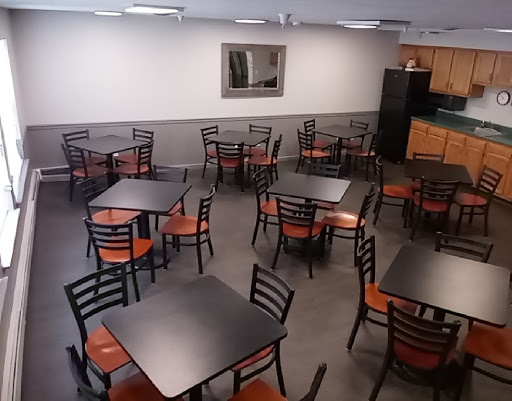 An empty dining area with several tables and chairs arranged for use.
