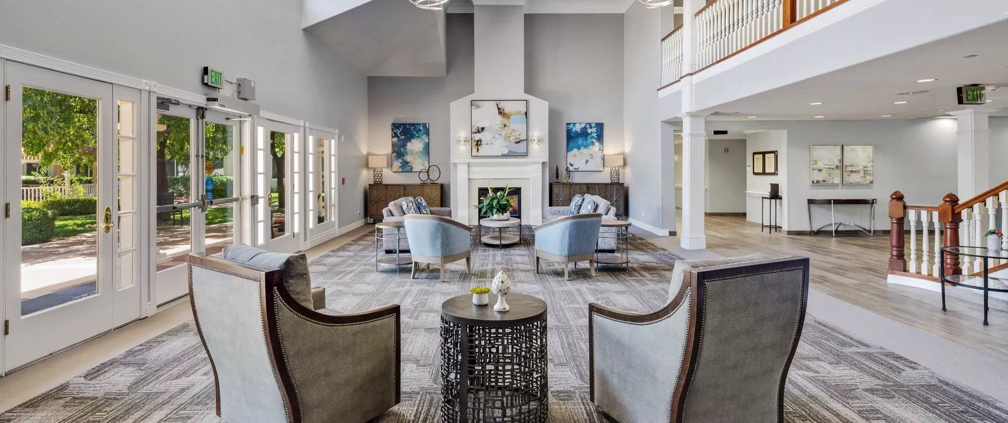 A spacious, modern living room with elegant decor and comfortable seating around a fireplace.