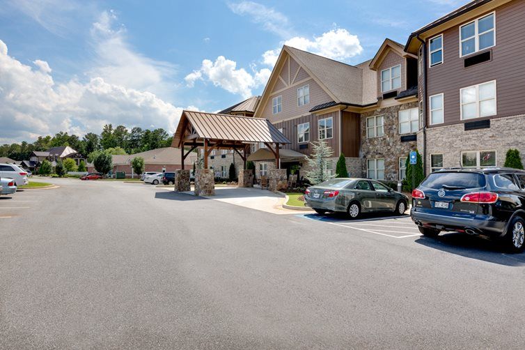 A hotel building with a parking lot under a partly cloudy sky.