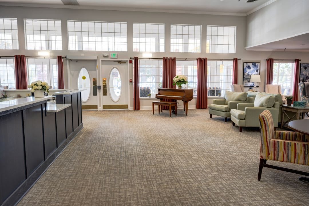 A spacious lobby with a piano and seating area.