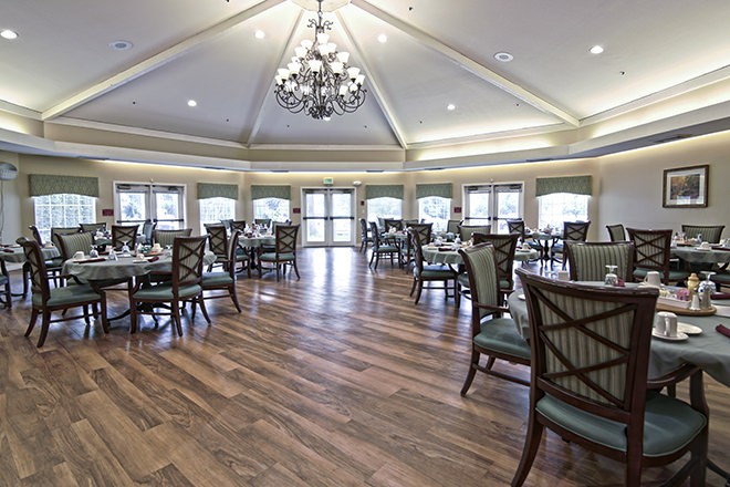 An elegant dining room with a chandelier and large windows.